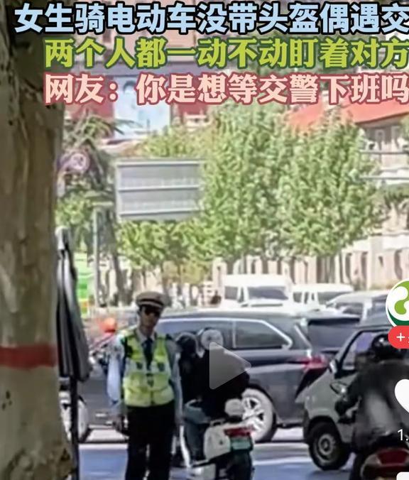 冲上热搜！女子骑车没戴头盔遇交警两人互盯！笑死在网友的评论区(图2)